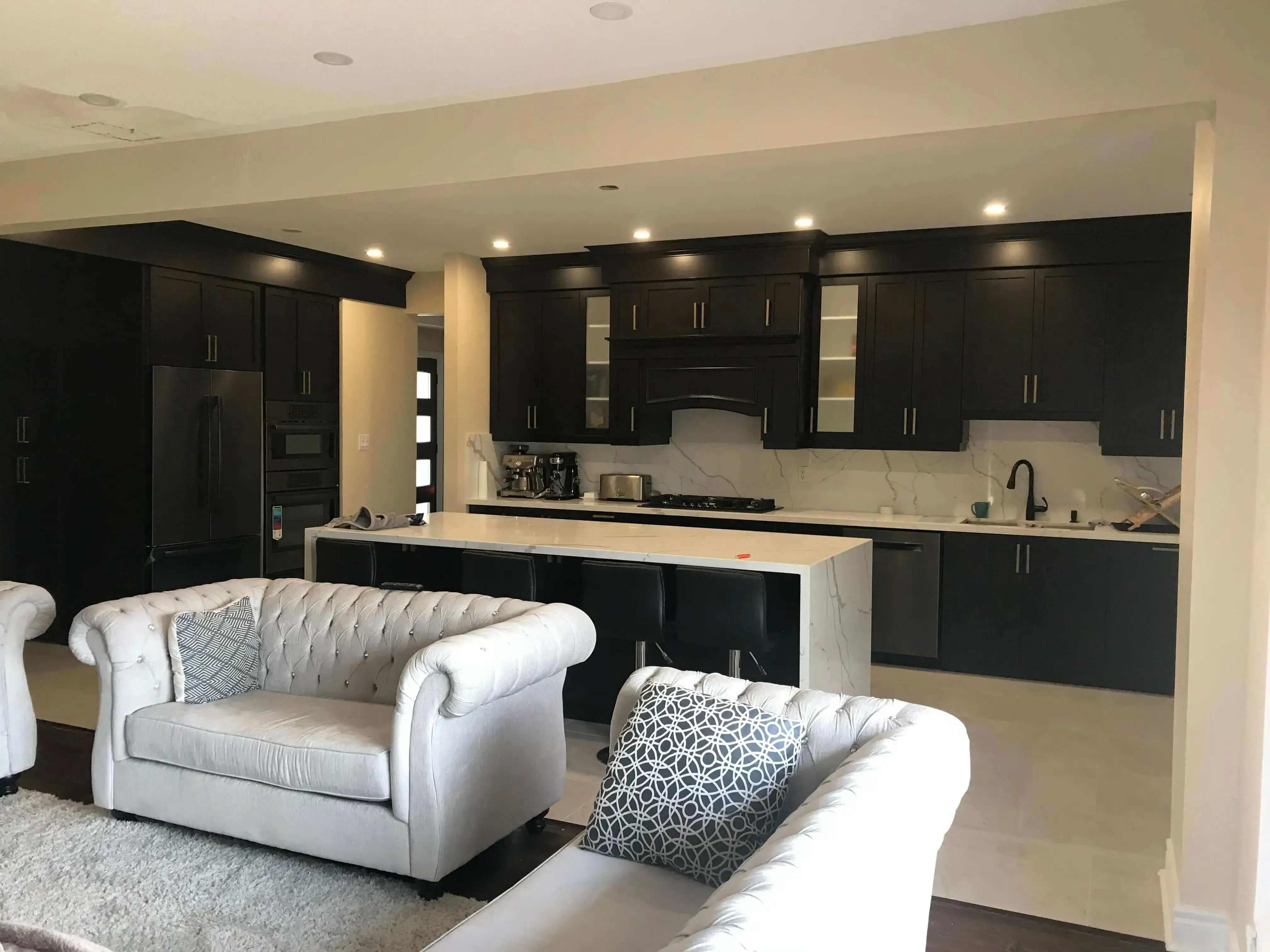 Open-concept kitchen with full-height dark cabinetry and a white island